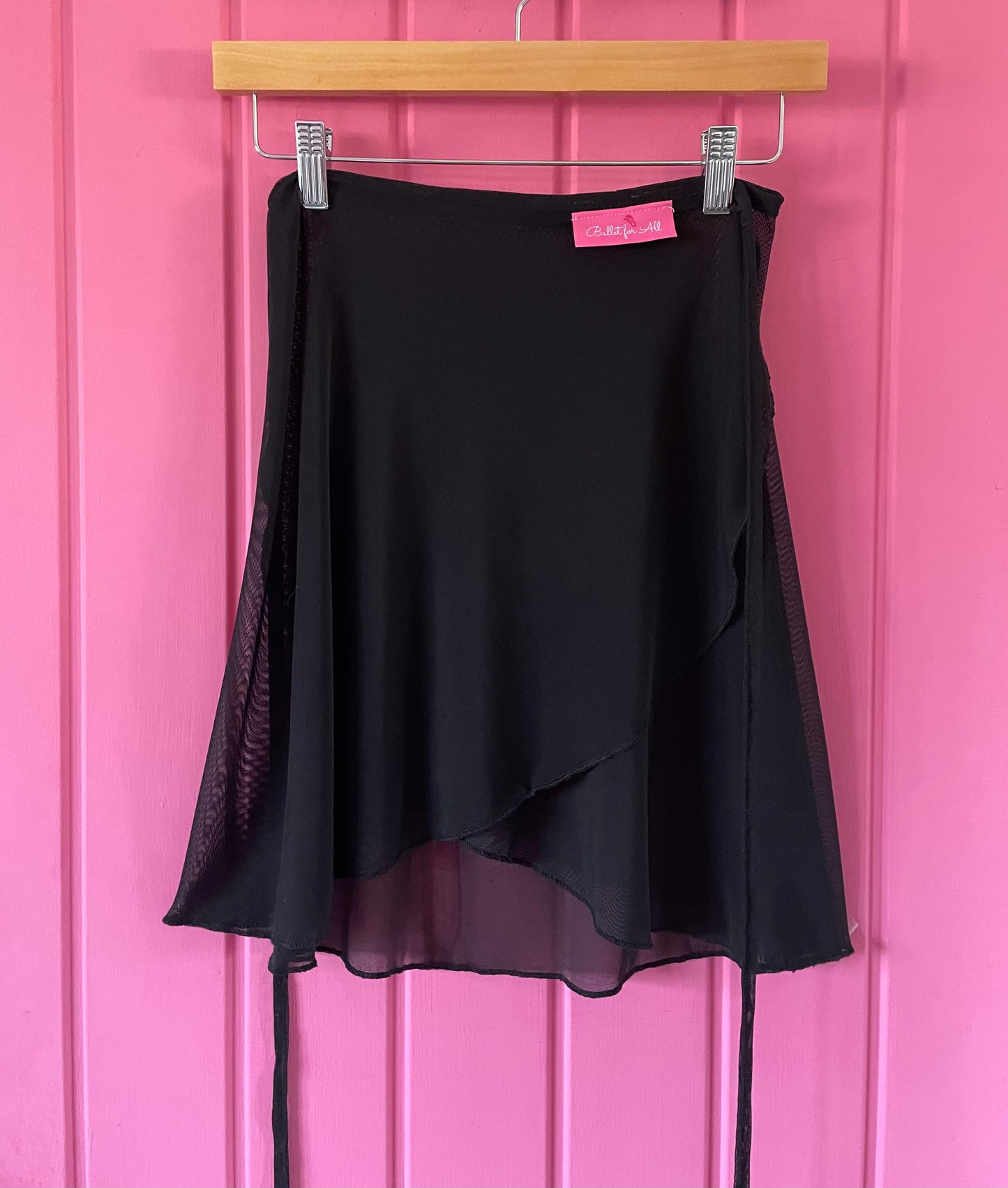Black skirt with sheer overlay on a pink background