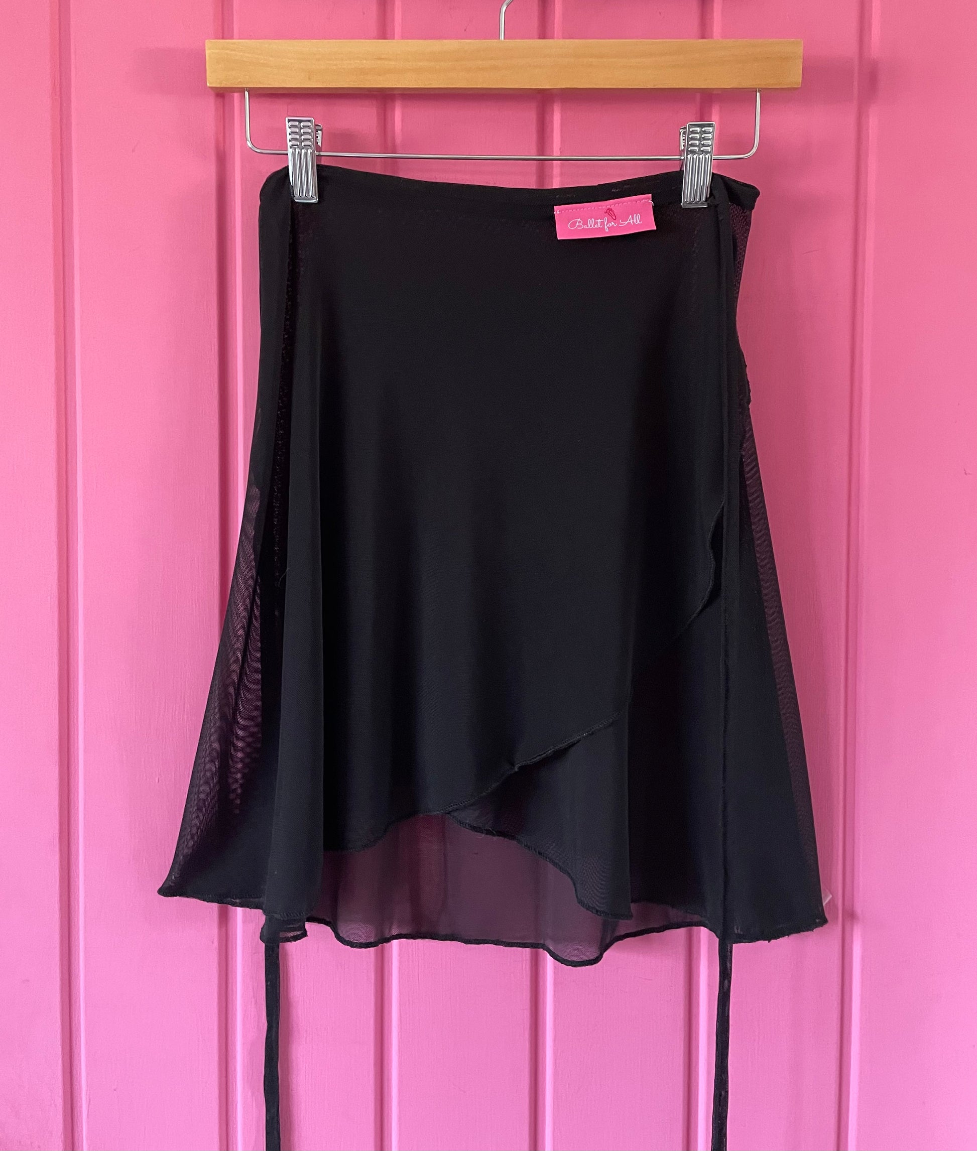 Black skirt with sheer overlay on a pink background